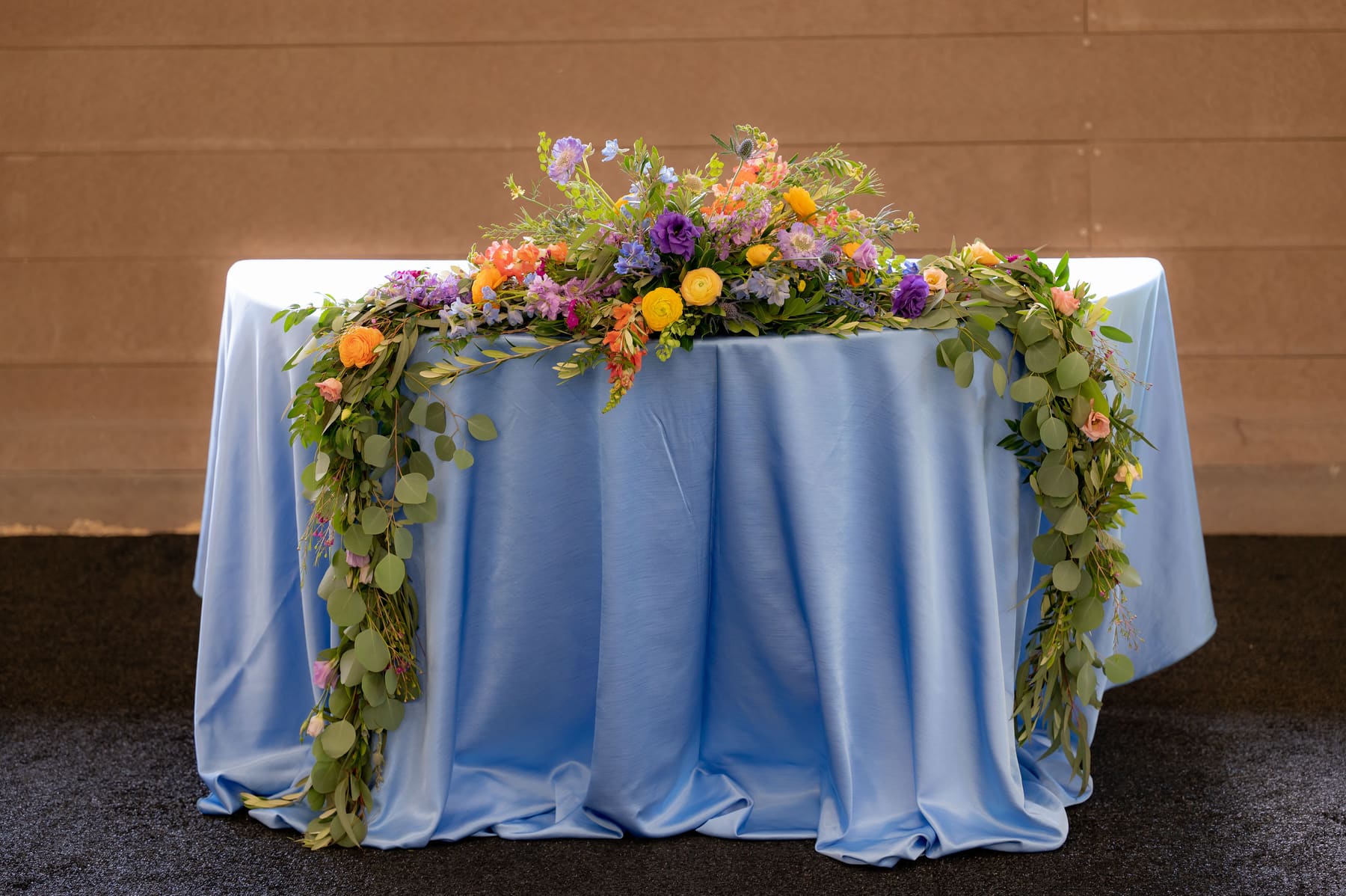 Head table with blue linens and flowers